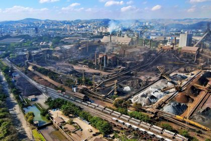 Vista aérea de uma área industrial do Rio de Janeiro, com fábricas e parte da paisagem urbana ao redor.