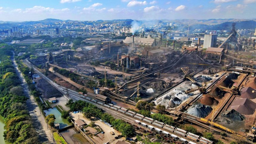Vista aérea de uma área industrial do Rio de Janeiro, com fábricas e parte da paisagem urbana ao redor.
