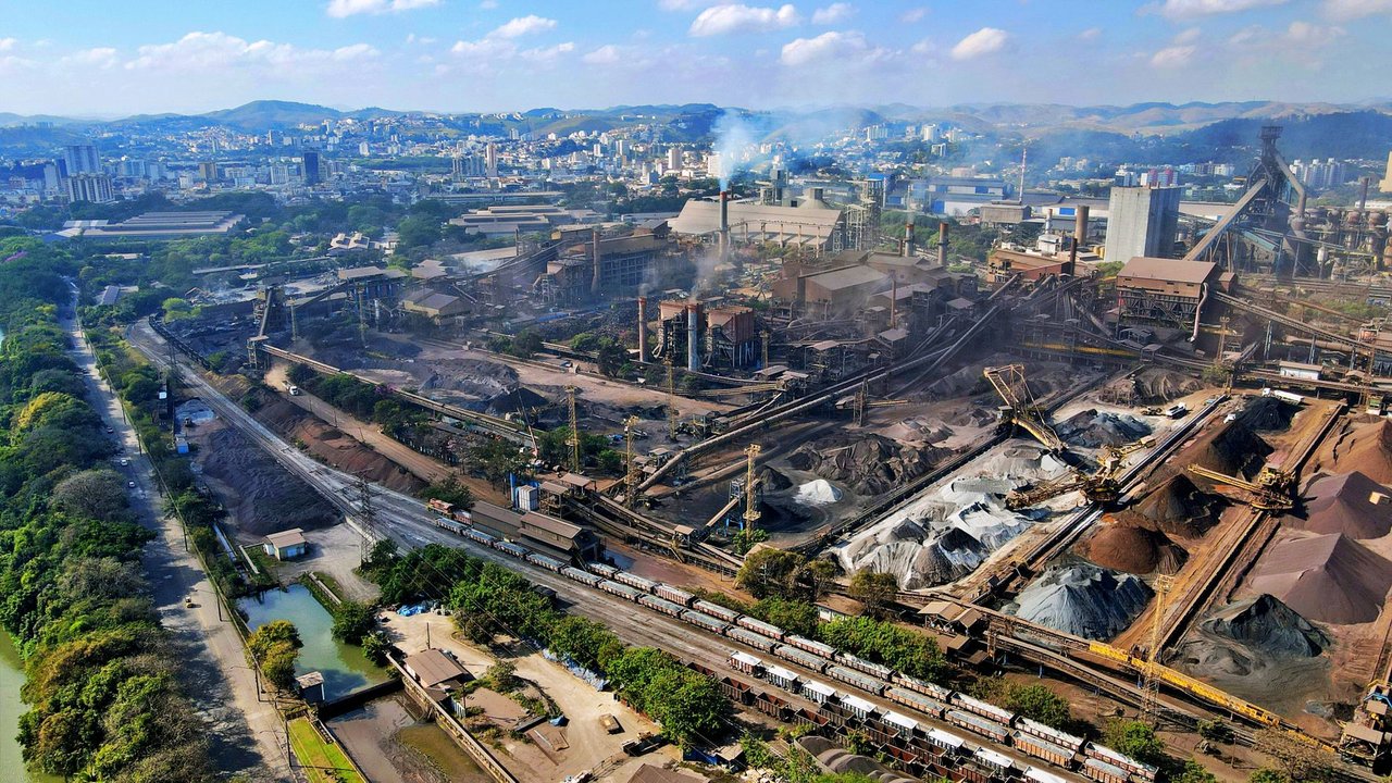 Vista aérea de uma área industrial do Rio de Janeiro, com fábricas e parte da paisagem urbana ao redor.
