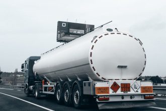 Caminhão-tanque transportando combustível em uma rodovia.