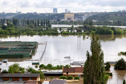 Vista aérea de uma cidade com ruas e construções parcialmente submersas por águas de enchente.