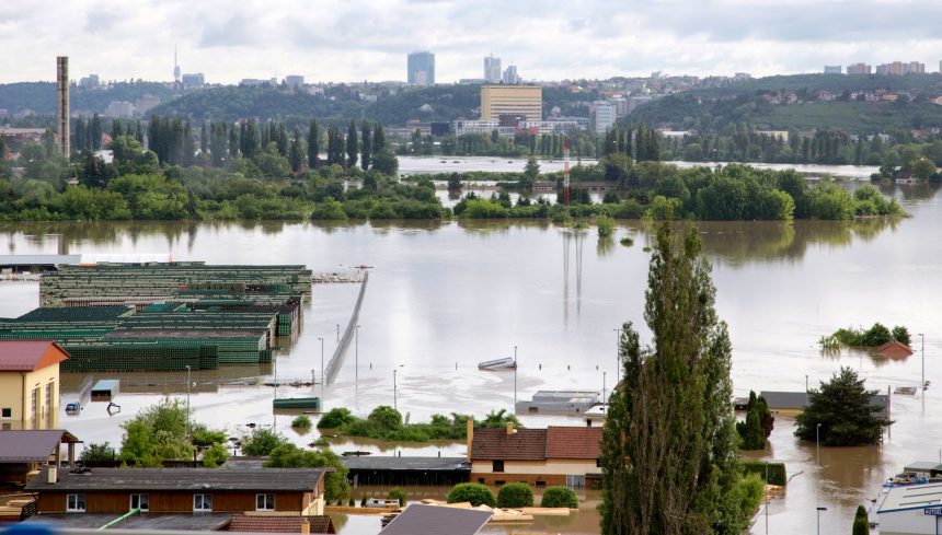 Vista aérea de uma cidade com ruas e construções parcialmente submersas por águas de enchente.